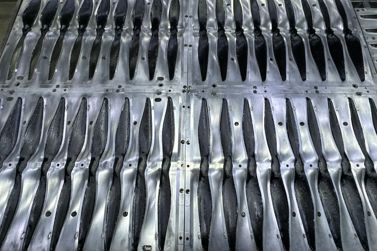 Aluminium mould plates laid out flat, each milled with rows of blade cavities
